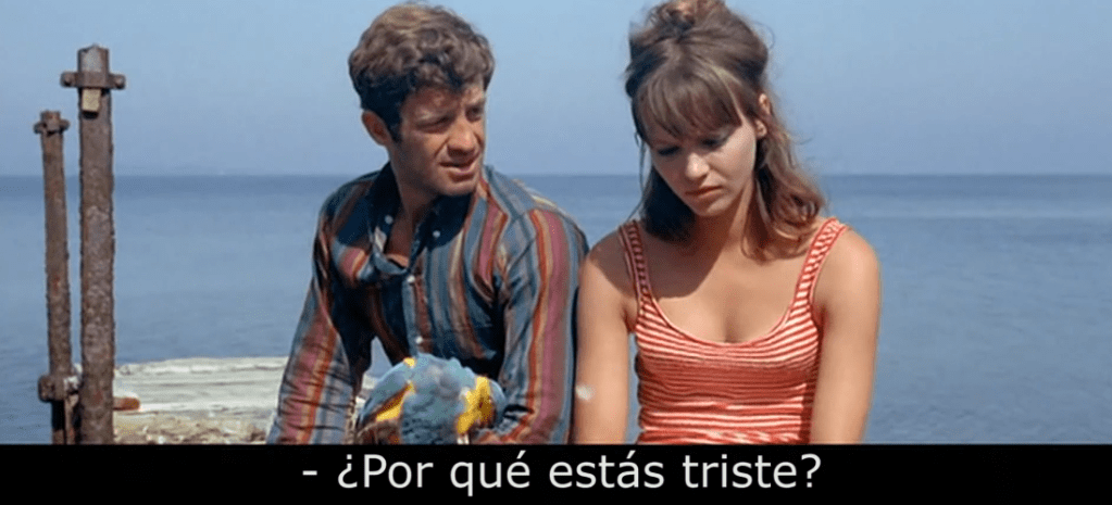 Jean-Paul Belmondo y Anna Karina conversando frente al mar en Pierrot le fou (1965) de Jean-Luc Godard.