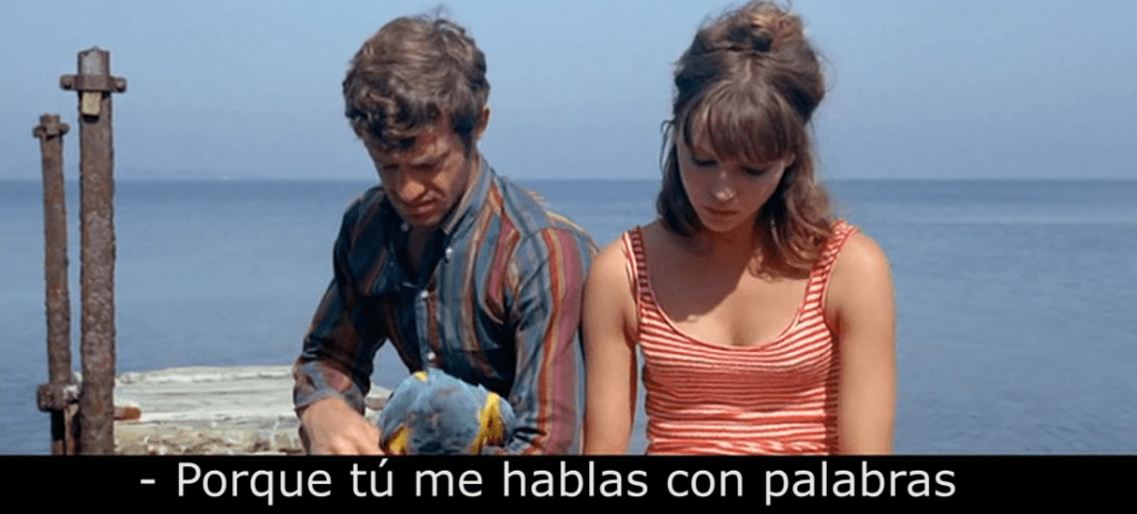 Jean-Paul Belmondo y Anna Karina conversando frente al mar en Pierrot le fou (1965) de Jean-Luc Godard.