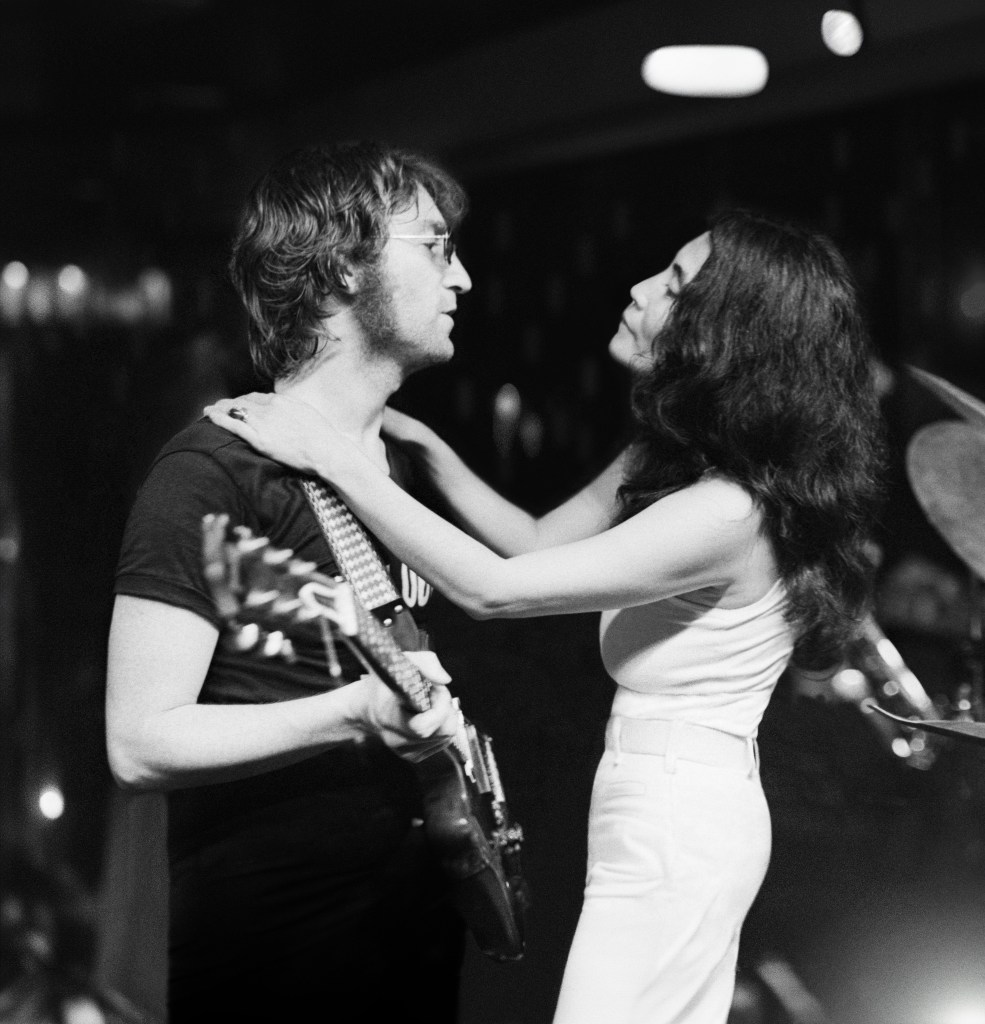 Still de John Lennon y Yoko Ono en su apartamento de Nueva York, con una guitarra de fondo
